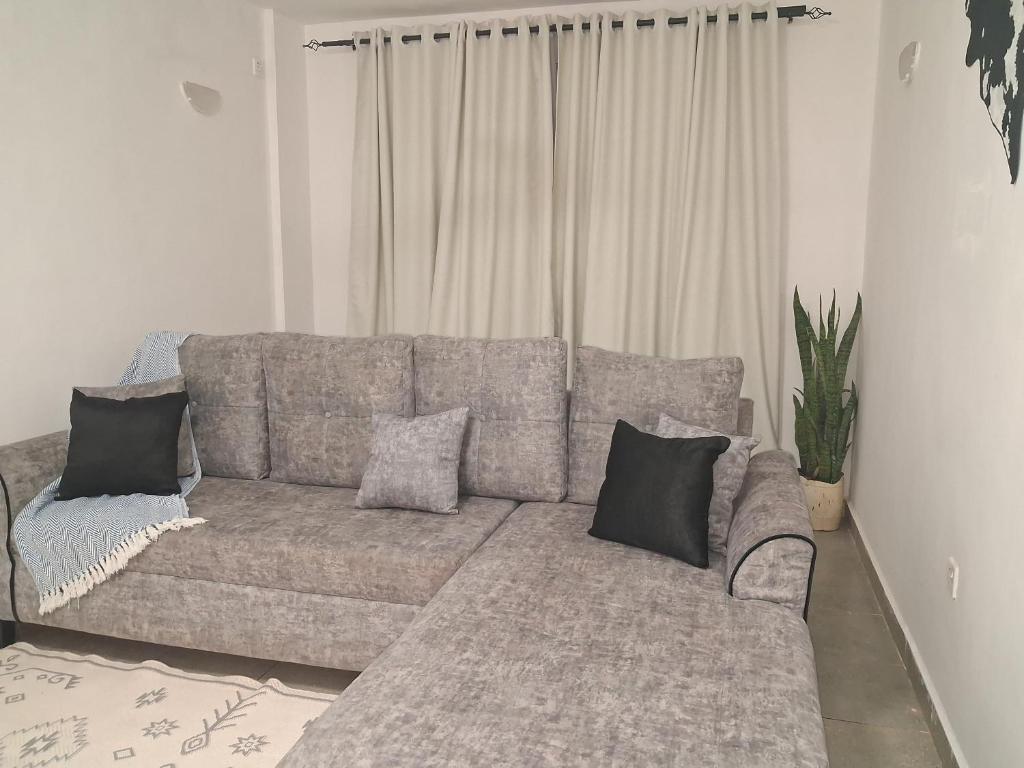 a gray couch with pillows in a living room at PAZURI - Homes2 in Voi