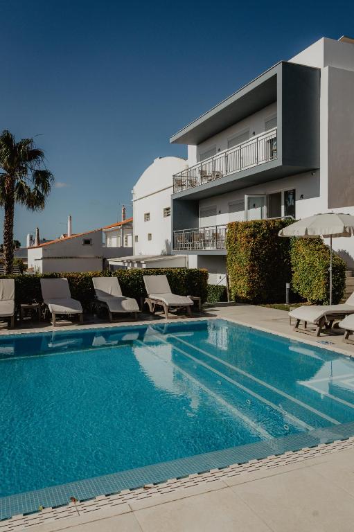 a swimming pool in front of a building at Boutique & Villas Boliqueime in Boliqueime
