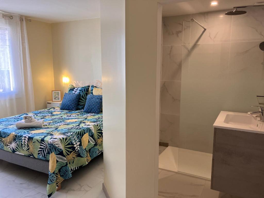 a bedroom with a bed and a shower and a sink at La Catalane in Perpignan