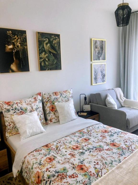 a bedroom with a bed and a couch and pictures on the wall at Elbląg Stare Miasto Bulvar, Old Town, Snake in Elblag