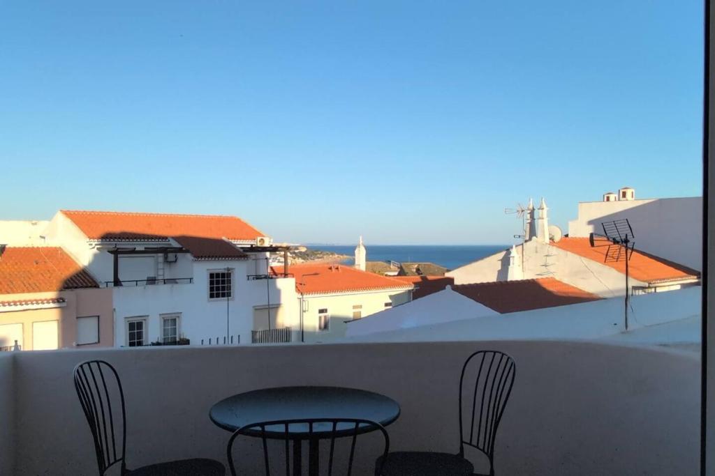 a balcony with two chairs and a view of the ocean at 1D Albufeiras Baysight flat in Albufeira