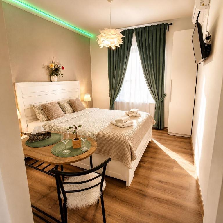 a bedroom with a bed with a table and green lights at Clar Studio Residence in Braşov