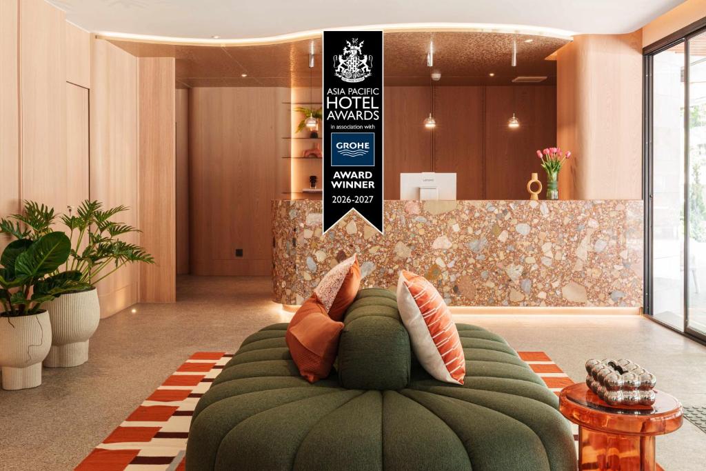 a green couch in the middle of a lobby at The Akyra Bangkok 11 in Bangkok