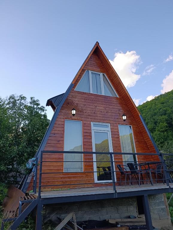 a cabin with a gambrel roof and windows at Cottage Irko in Tvebishi