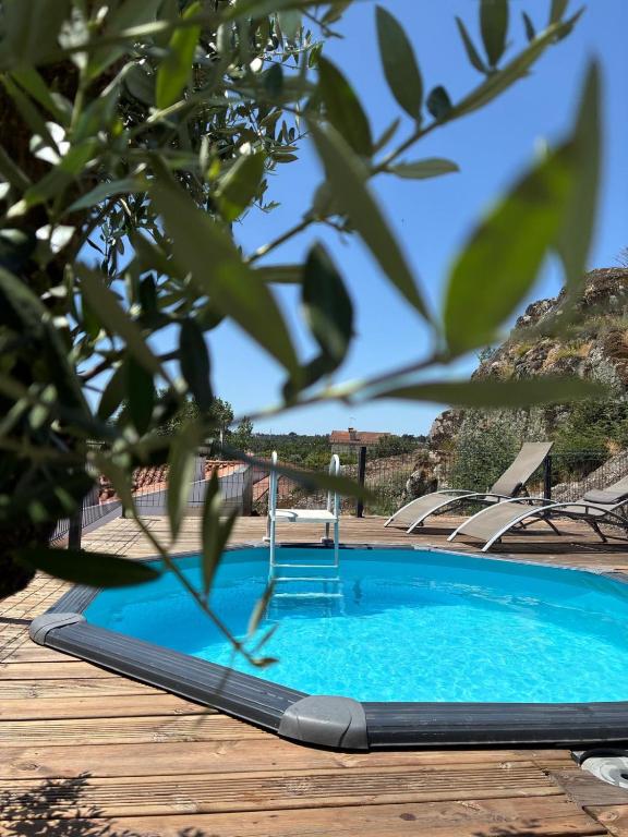 a blue swimming pool on a wooden deck at Segredos da Montanha - Seia in Seia
