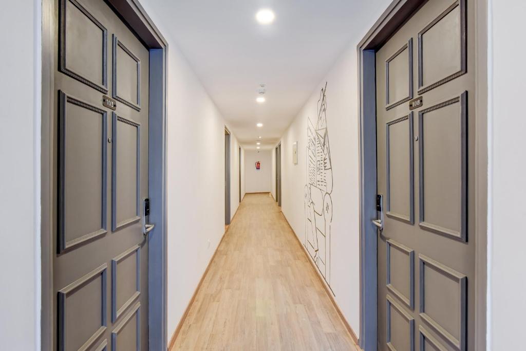 a hallway with two doors and a long hallway at Hotel O Crowninn in Faridabad