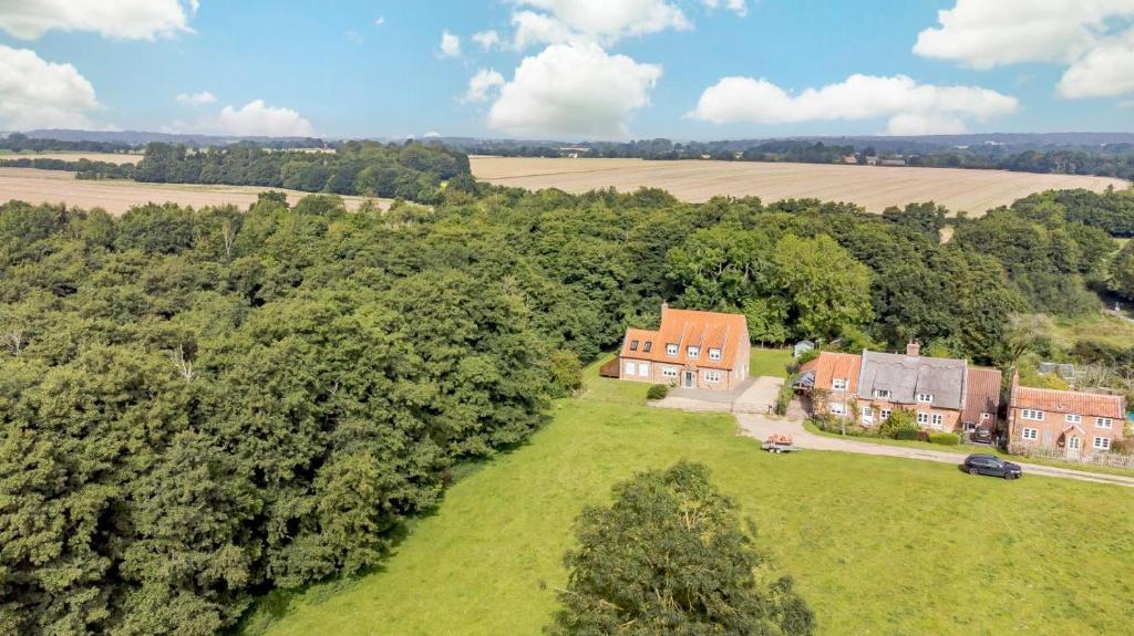 an aerial view of a house on a green field at 5 Bed in Hanworth Common oc-1650 in Thurgarton