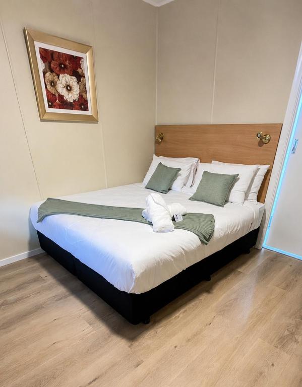 a bedroom with a large bed with white sheets at Murrurundi Motel - CITY CENTRE in Murrurundi