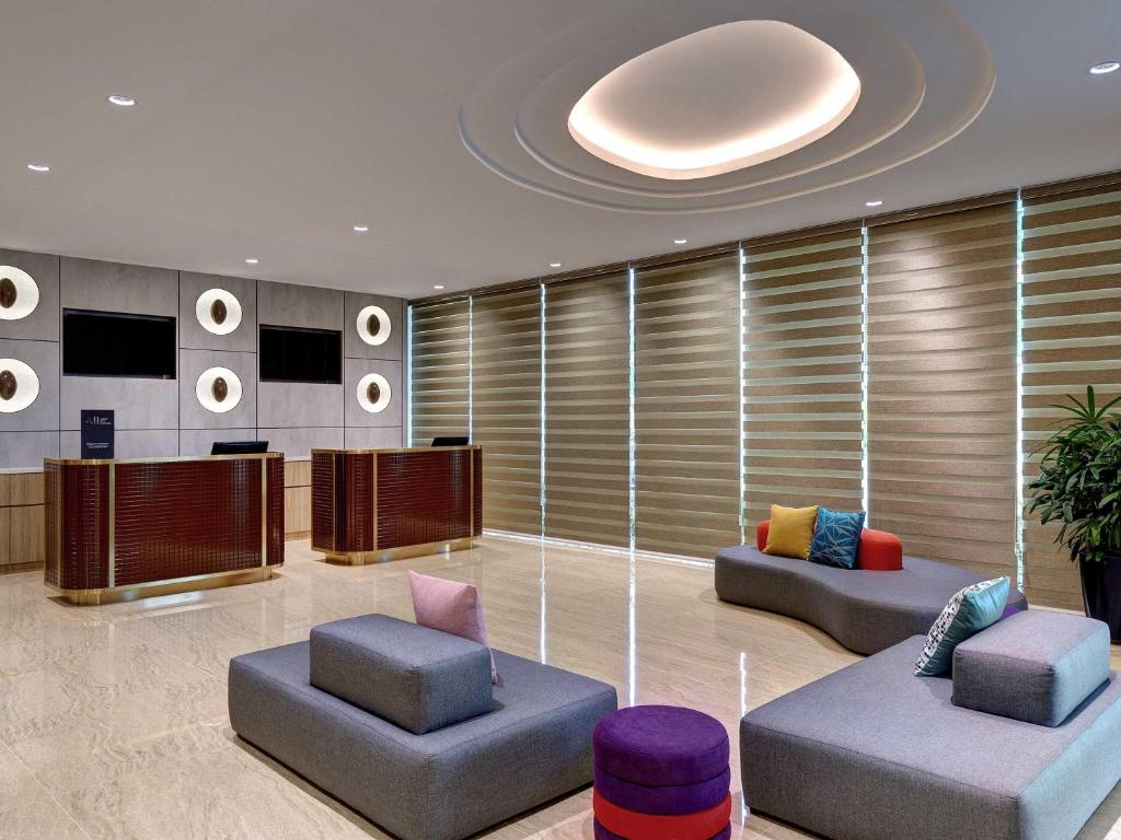 a lobby with two couches and a podium at ibis Styles Johor Iskandar Puteri in Johor Bahru