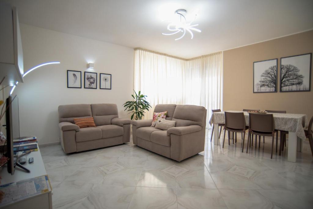 a living room with two chairs and a table and a dining room at A casa di Chiara in Lecce