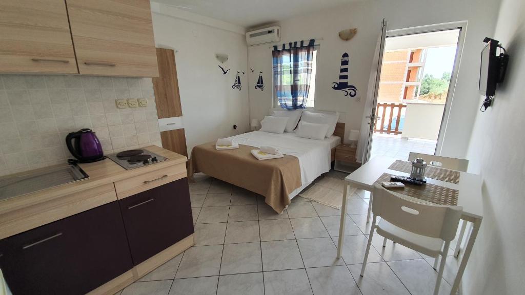 a room with a bed and a table and a kitchen at Budget Holiday Apartments Primorska in Pag