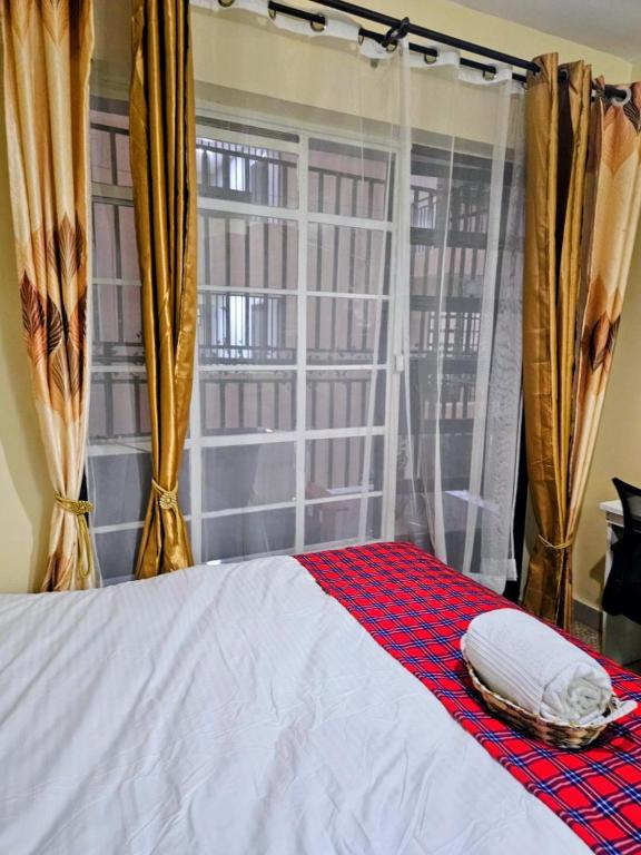 a bedroom with a bed and a window with curtains at The Loft 21 Ngara, Nairobi in Nairobi