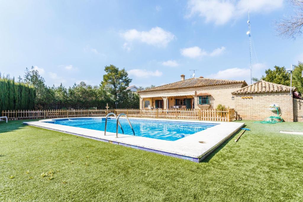 a swimming pool in the yard of a house at Divi Apartments Villa Reyes in Mairena del Aljarafe