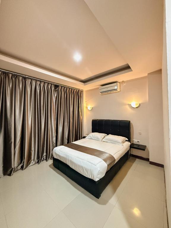 ein Schlafzimmer mit einem Bett und einem großen Fenster in der Unterkunft arafah hotel in Sungaipenuh