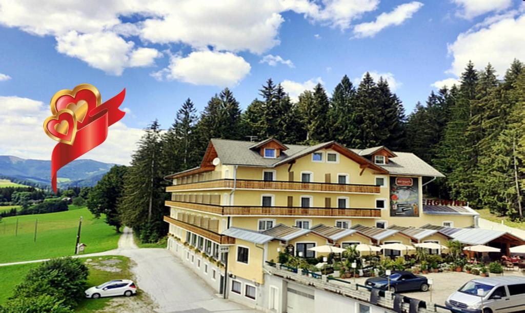a large yellow building with a large red flower on it at LiebesNesterl Bergwirt - Boutique Hotel in Köflach