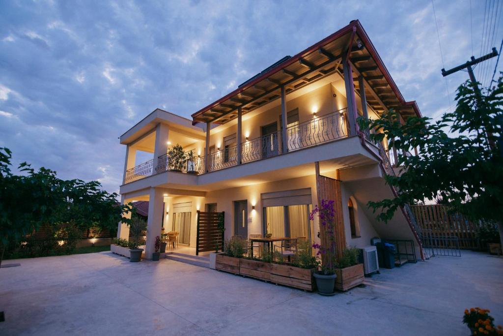 a large house with a balcony on the side of it at Maresol Villa in Nea Kallikrateia