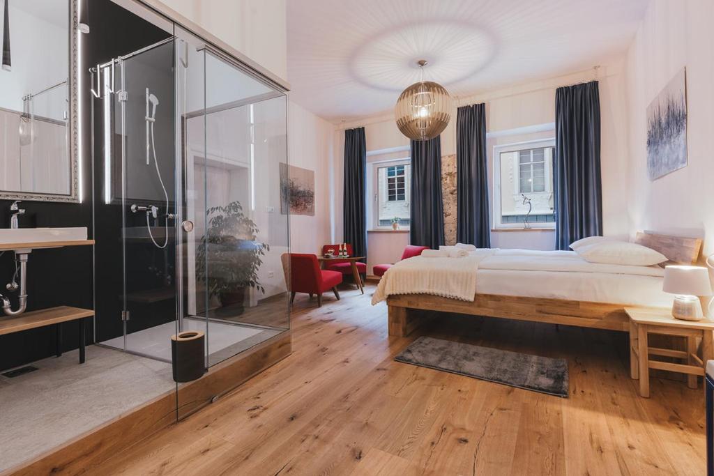 a bedroom with a bed and a glass shower at Sobe Lotrist in Radovljica