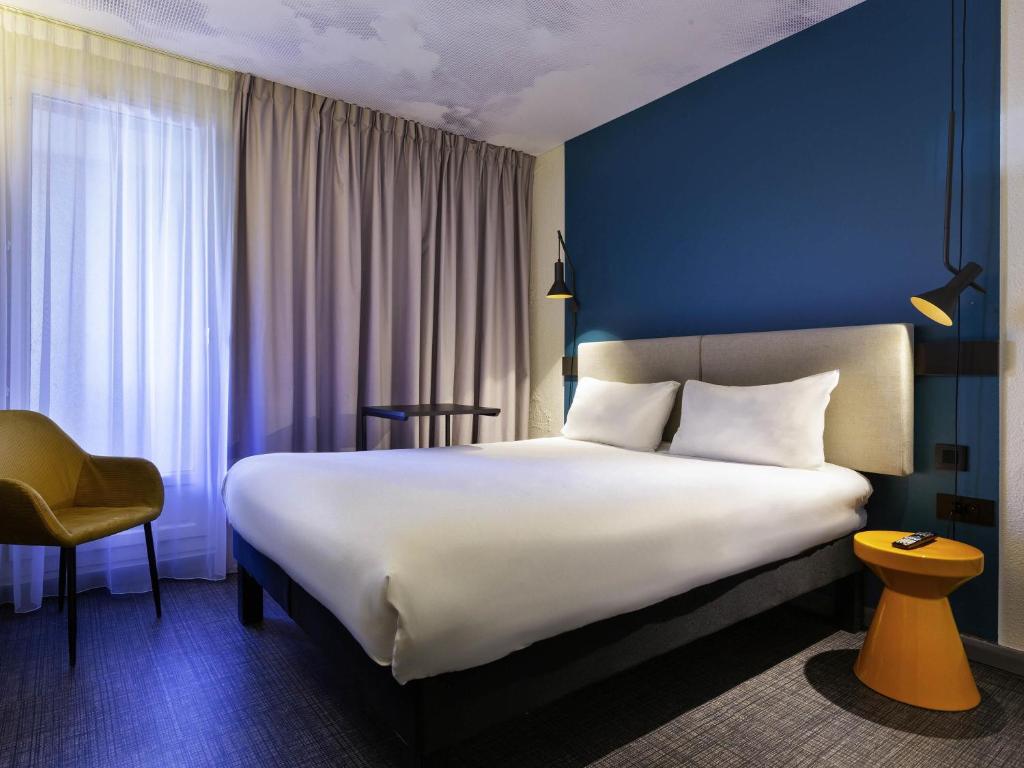 a hotel room with a large bed and a chair at Ibis Marseille Centre Prefecture in Marseille