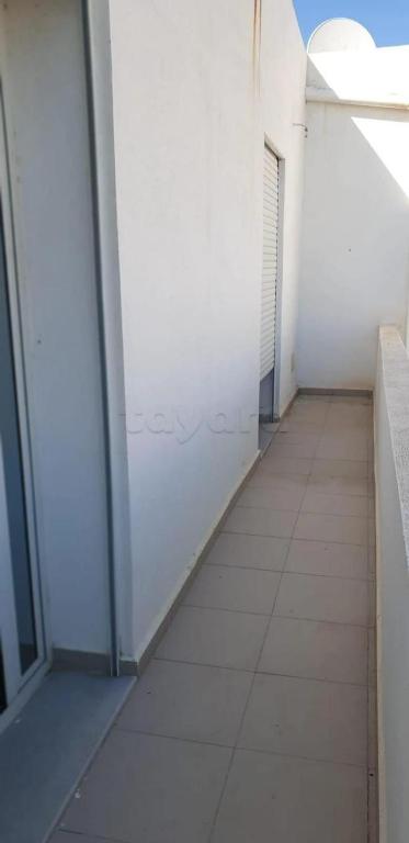 an empty hallway of a white building with a window at Dar Frdj in Sousse