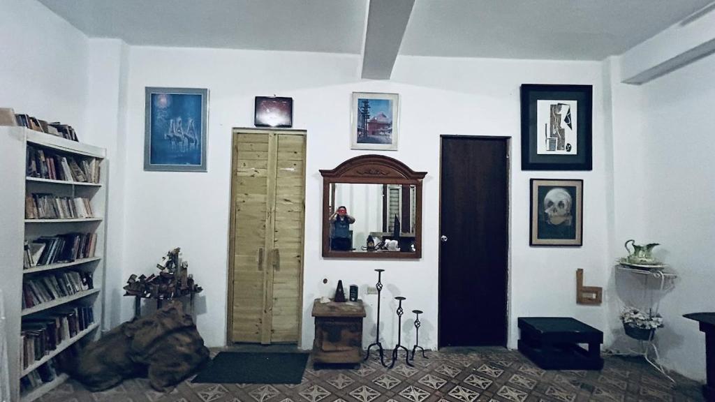 a room with a book shelf and a mirror at Casa-Museo centro de Caguas in Caguas