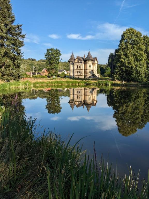 an old house reflected in the water of a lake at Le clos du Breuchin in Breuchotte