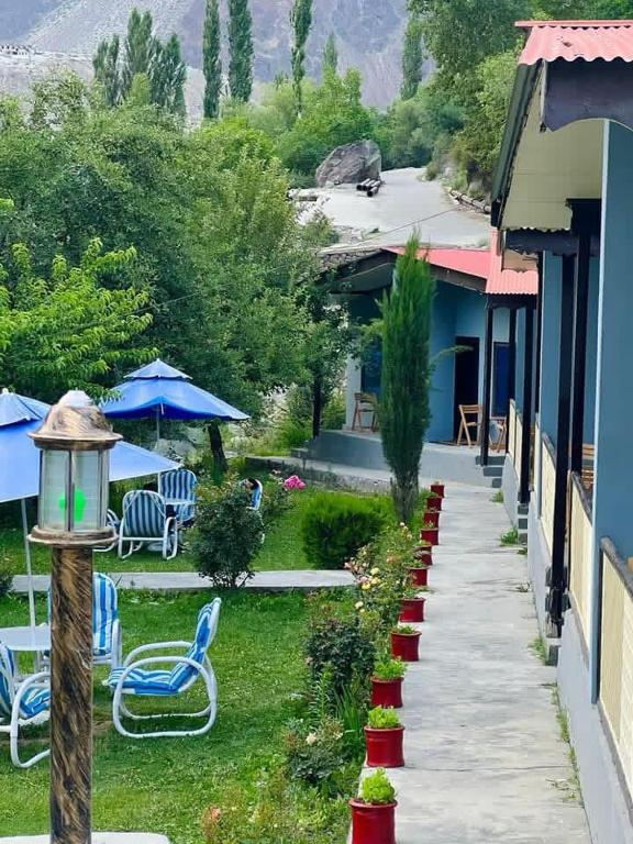 a pathway leading to a house with chairs and umbrellas at Hills n Huts in Hini