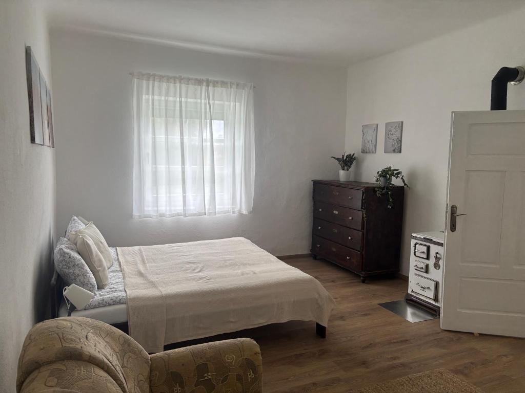 a bedroom with a bed and a dresser and a window at Tornácos Vendégház in Szécsény