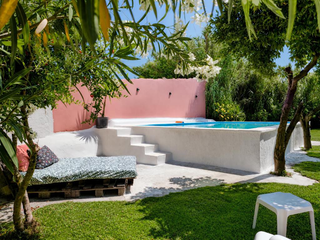 a backyard with a swimming pool and a chair at Quinta da Ponte das Hortas 3 in Elvas