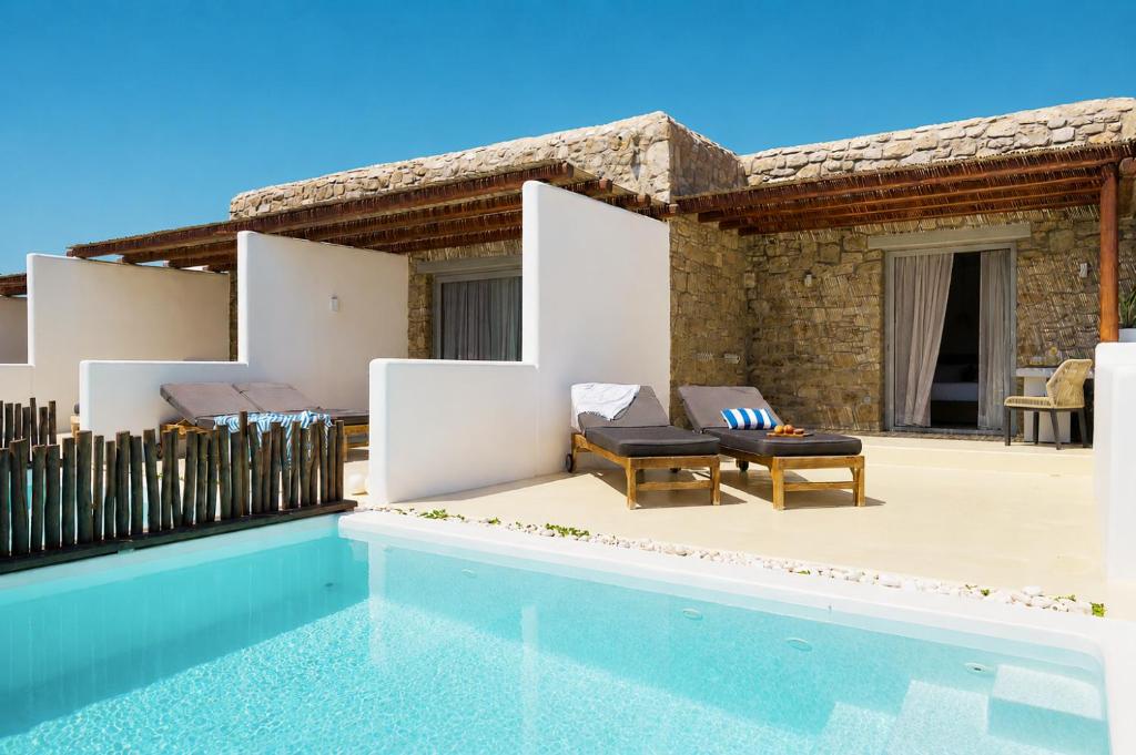 a villa with a swimming pool and a house at Aegean Hospitality in Mikonos