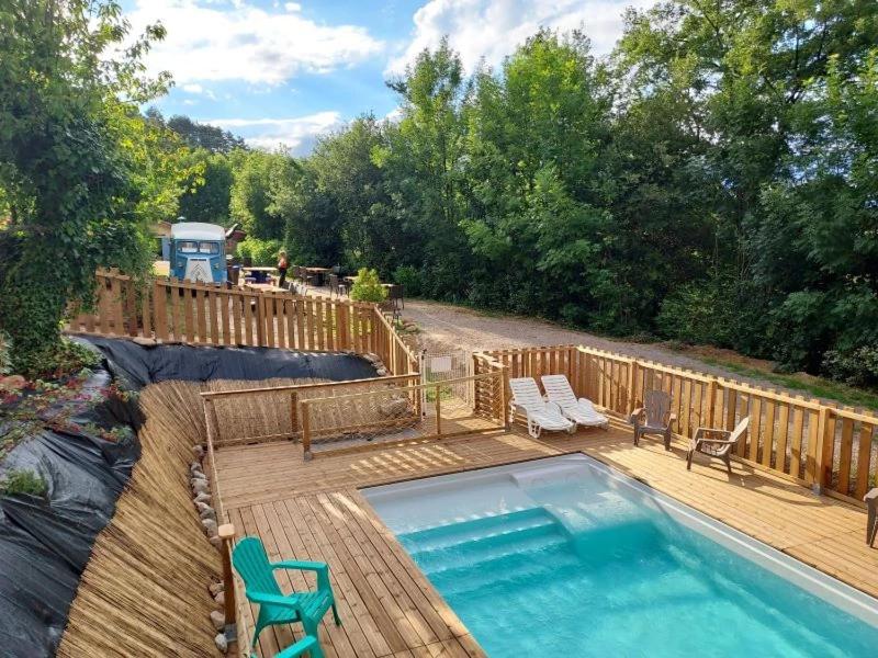 a swimming pool on a wooden deck next to a wooden fence at Camping 2 étoiles - Piscine - ccbfida in Vernet-les-Bains