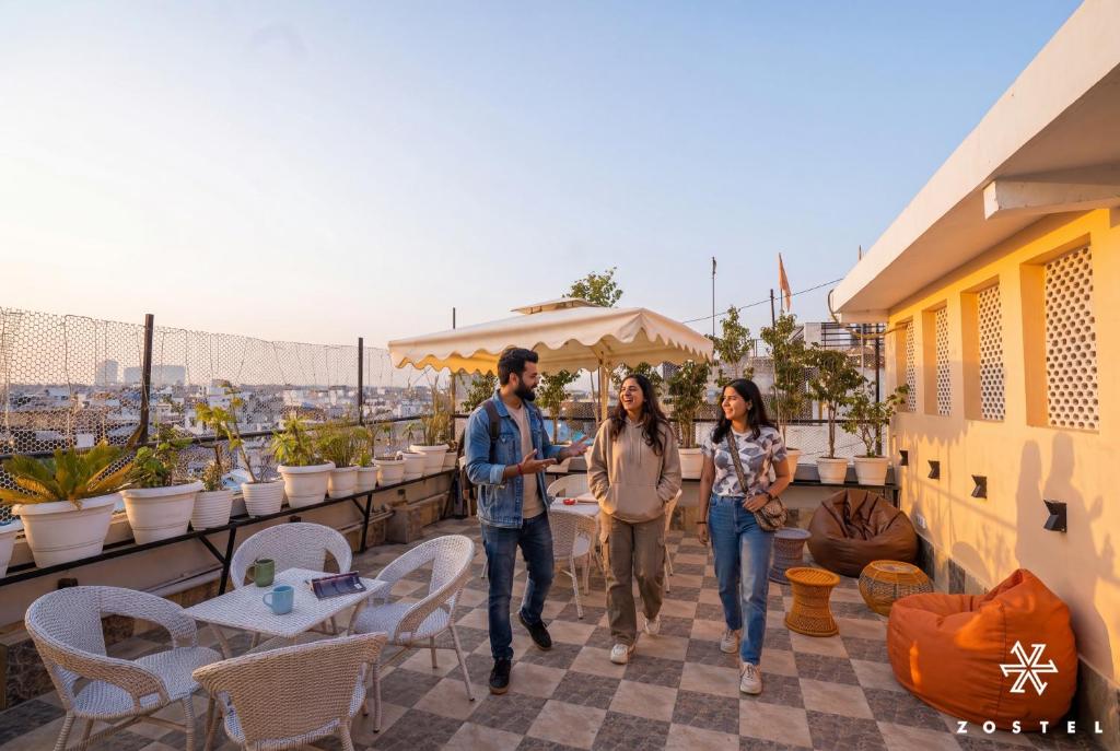 a group of three people walking on a balcony at Zostel Delhi in New Delhi
