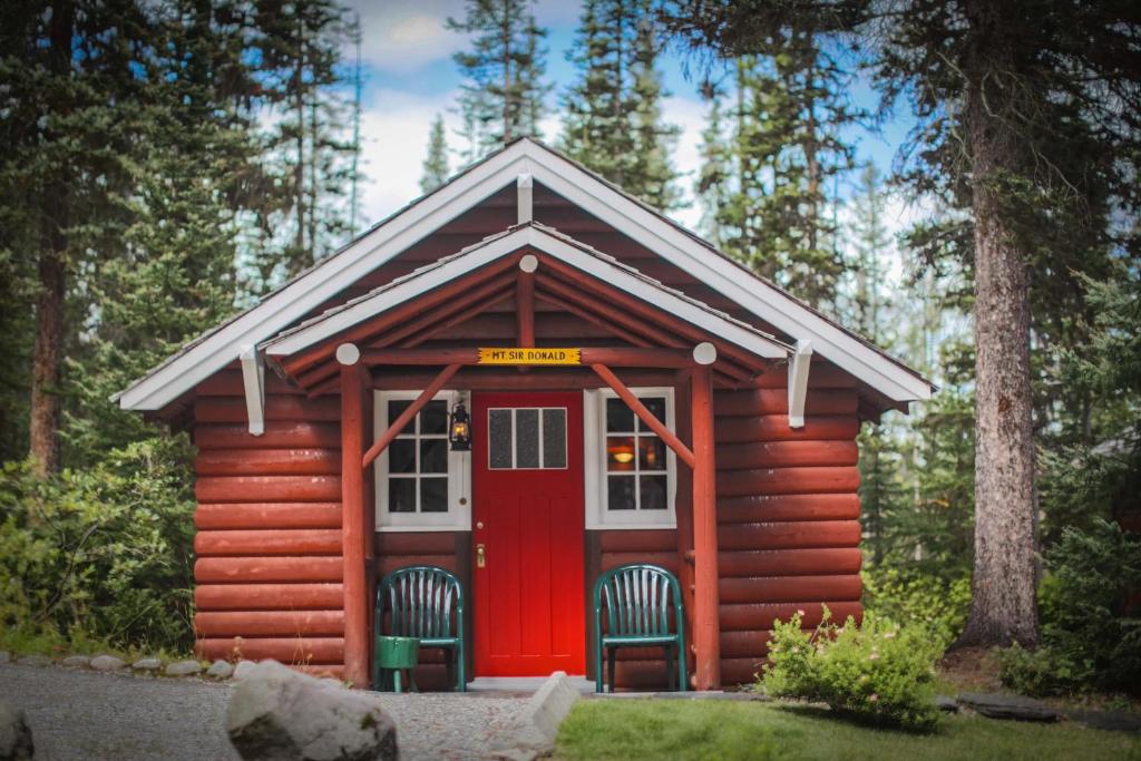 a red cabin with two chairs in front of it at Paradise Lodge and Bungalows in Lake Louise