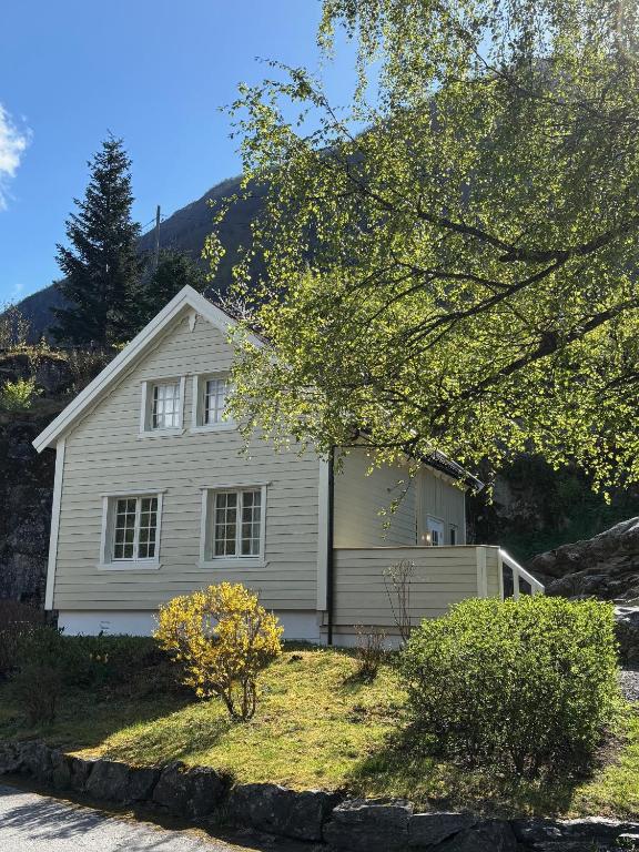 a white house with a mountain in the background at Lodge Visnes Stryn in Stryn