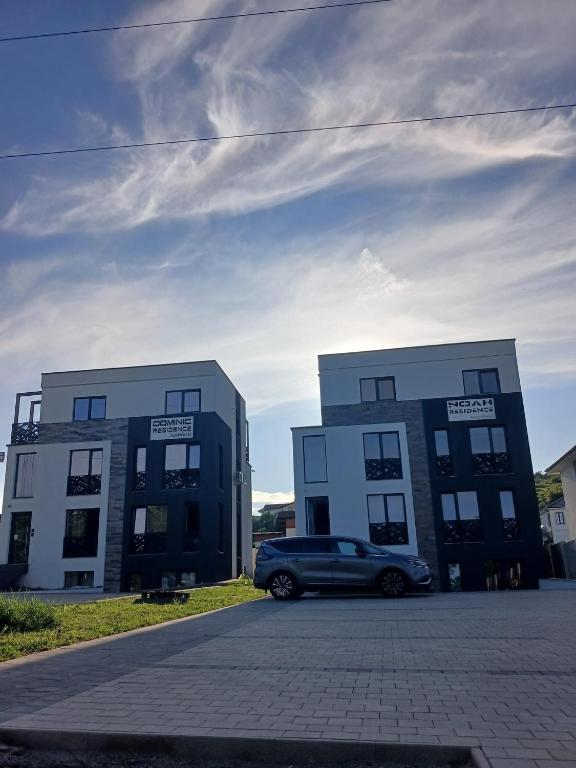 a car parked in front of two buildings at ApartHotel NoahResidence in Alba Iulia