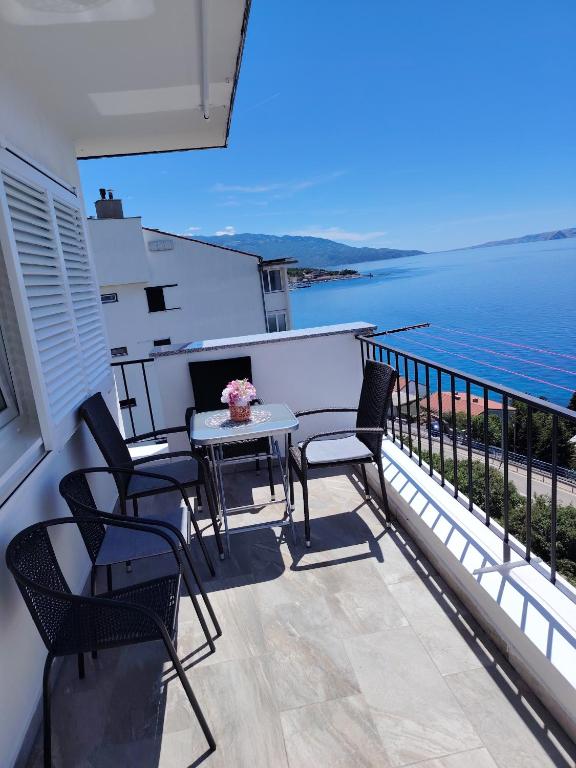 a balcony with chairs and a table with a view of the water at Apartman David in Senj