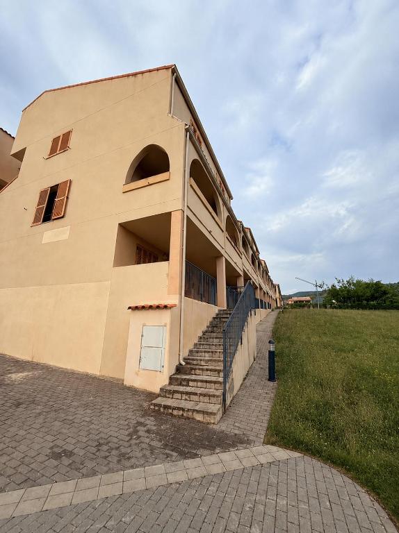 a building with stairs next to a grass field at Bungalow Esqui II Ref 076 in La Virgen de la Vega