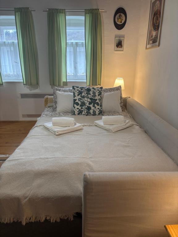 a large bed in a room with green curtains at Sárga-part Vendégház in Cserépváralja