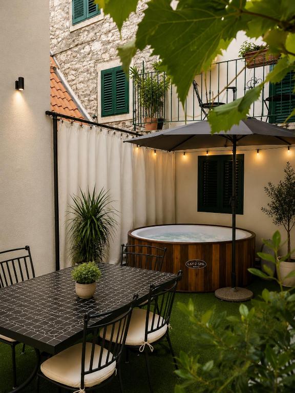 a table and chairs on a patio with a hot tub at Quiet Oasis in the Heart of Old Town- two kitchen,3bath in Split