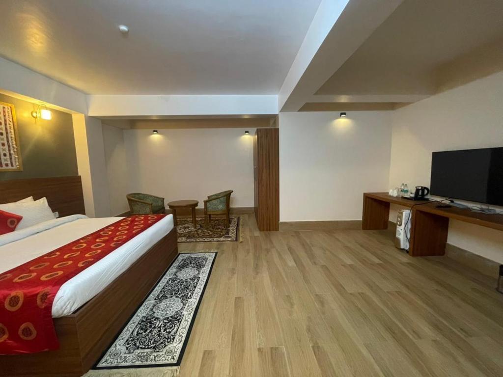 a hotel room with a bed and a flat screen tv at The Pham Inn in Bomdila