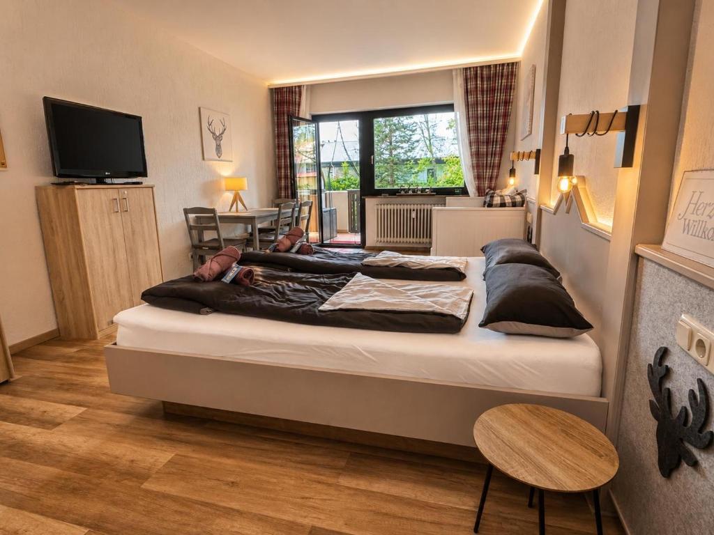 a large bed in a room with a tv at Ferienwohnung Darosa Alpenliebe in Seeg