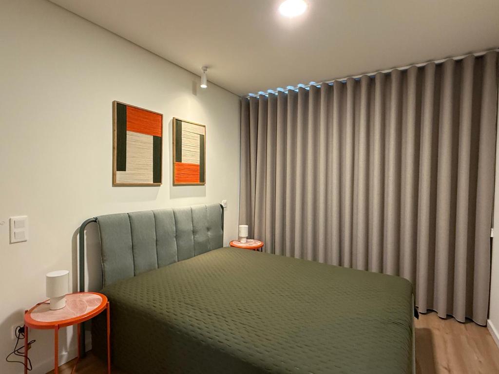 a bedroom with a green bed and a window at La Maison de Ré in Vila Real