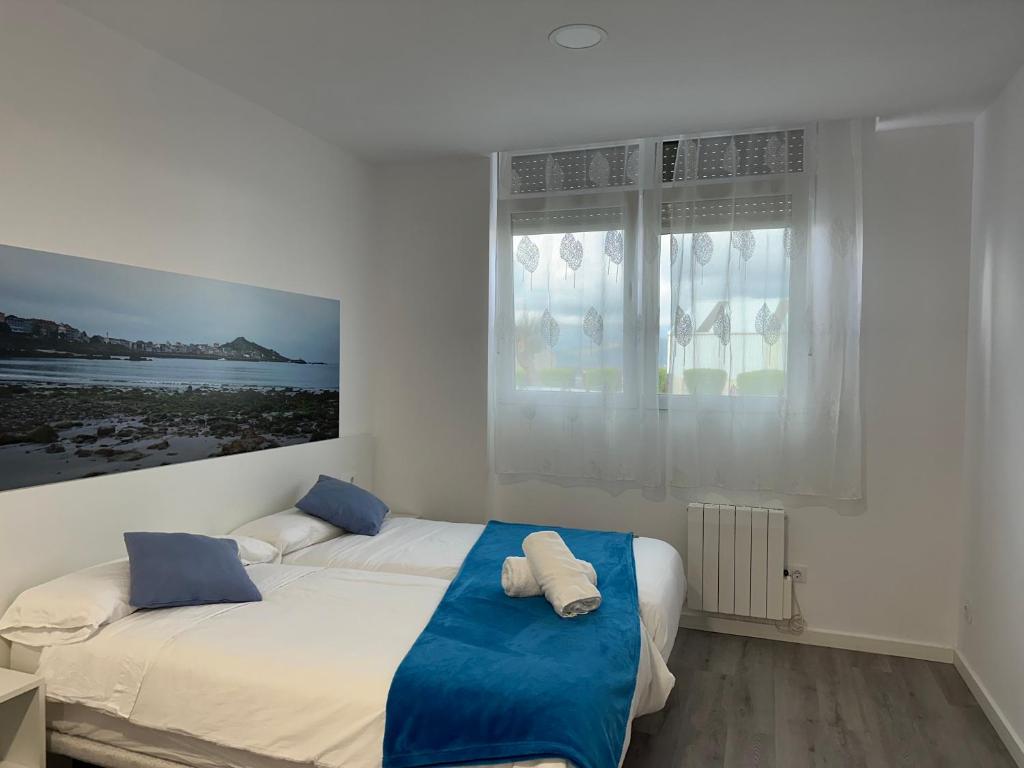 a bedroom with a bed with two pillows on it at GRUPOELE3 MUXIA PUERTO in Muxia