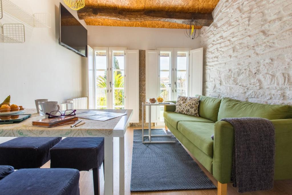 a living room with a green couch and a table at roomPEDRA apartamentos turísticos in Santiago de Compostela