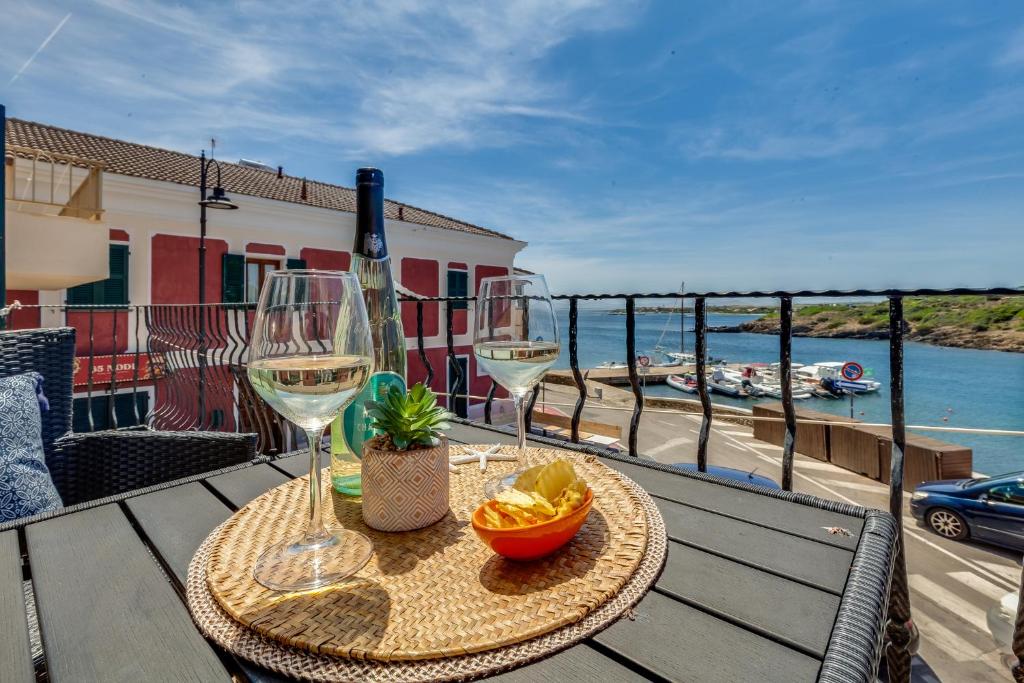 a table with two glasses of wine on a balcony at Blue Horizon Stintino in Stintino