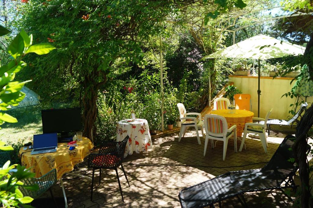 a patio with a table and chairs and an umbrella at Haus Zypresse in Saint-Saturnin-lès-Apt