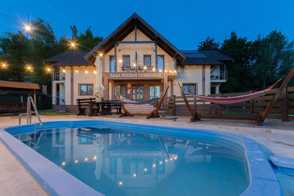 a house with a pool and a hammock in front of it at Casa Bocskai-Vendégház in Sovata