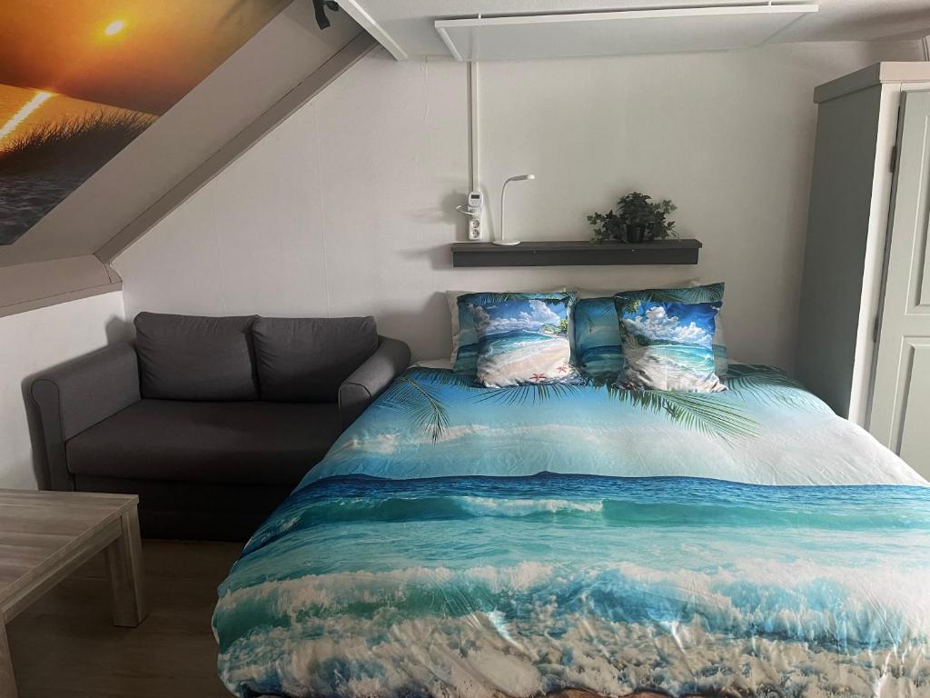 a bedroom with a bed and a couch at Studio vlak bij het strand in Petten