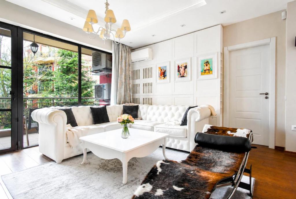 a living room with a white couch and a table at Top 10 3BR2BH Jacuzzi Free Parking in Sofia