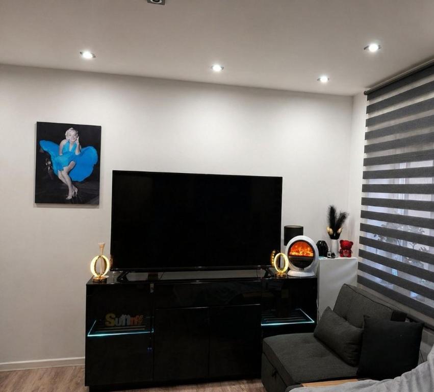a living room with a large flat screen tv at Blackapartment2Kawalerka in Olsztyn