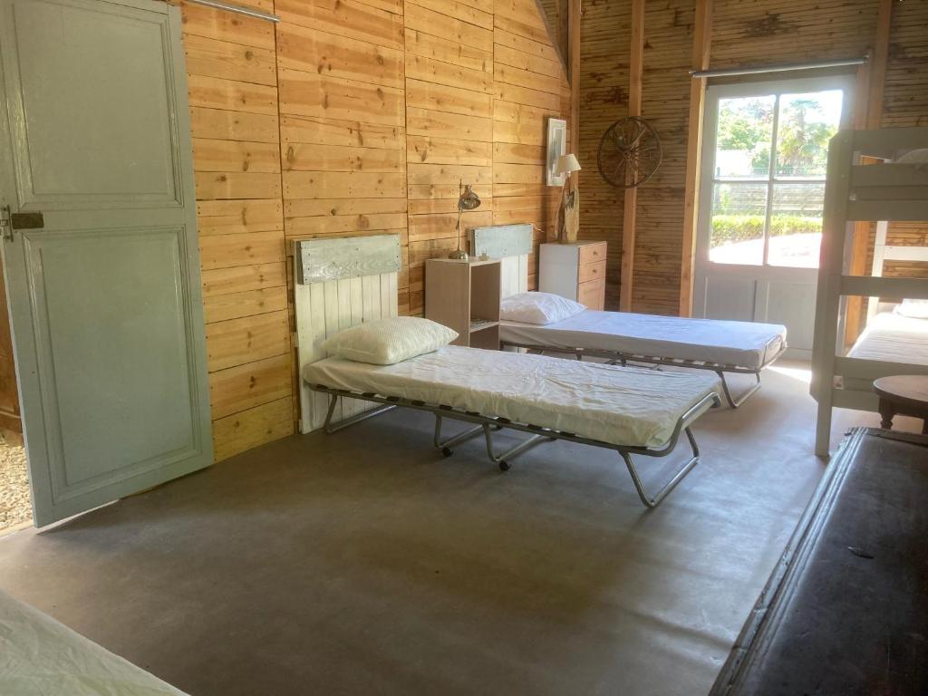 a room with two beds in a wooden wall at Dortoir en charente in Jarnac